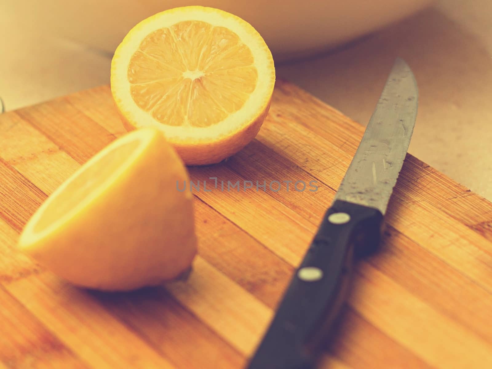 Two limes sitting on top of a wooden cutting board. High quality photo