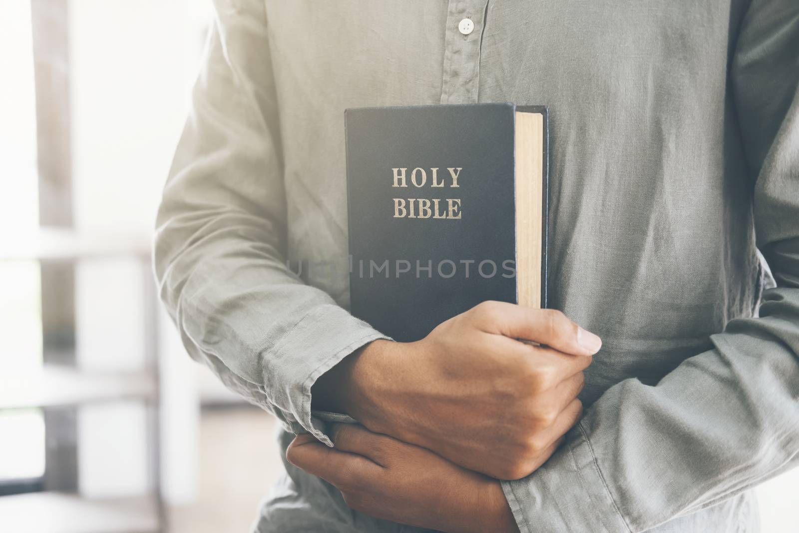 Religion Christianity concept. Man holding and reading the holy Christian Bible.