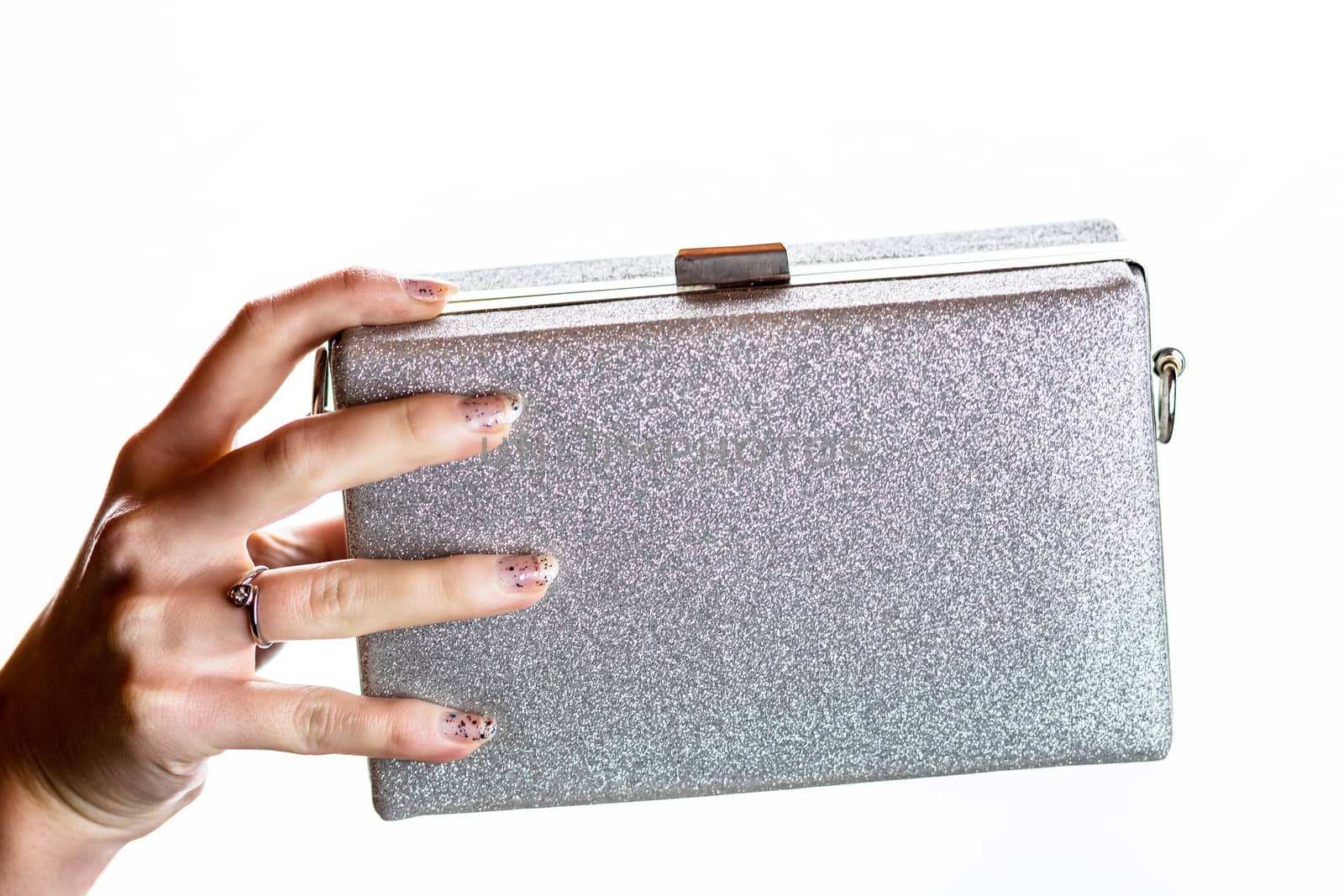 Woman hand holding glittery silver clutch bag isolated on white background with copy space.