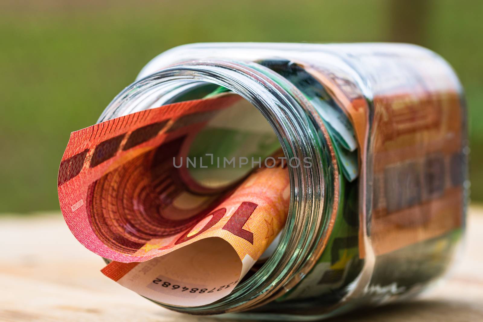Composition with saving money banknotes in a glass jar. Concept  by vladispas