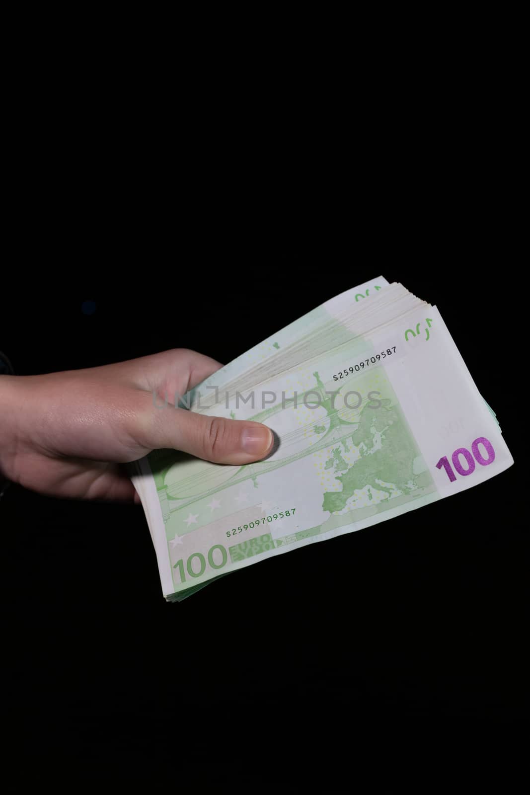 Hand counting holding and showing euro money or giving money. World money concept, 100 EURO banknotes EUR currency isolated on black with copy space. Concept of rich people, saving or spending money