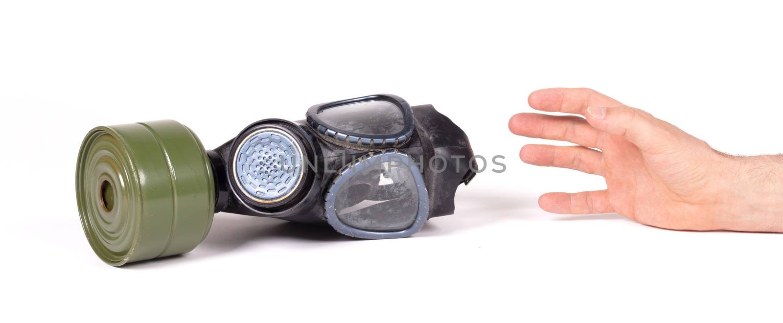 Arm reaching for vintage gasmask isolated on a white background - Green filter