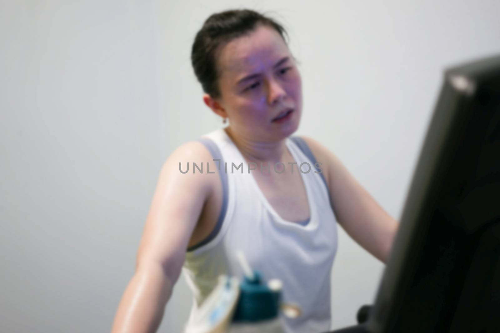 blur photo of tired woman jogger on treadmill