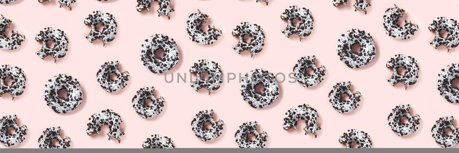 donuts on a pink background top view. Flat lay of delicious nibbled chocolate donuts. used as donut banner or poster background, not pattern. by PhotoTime