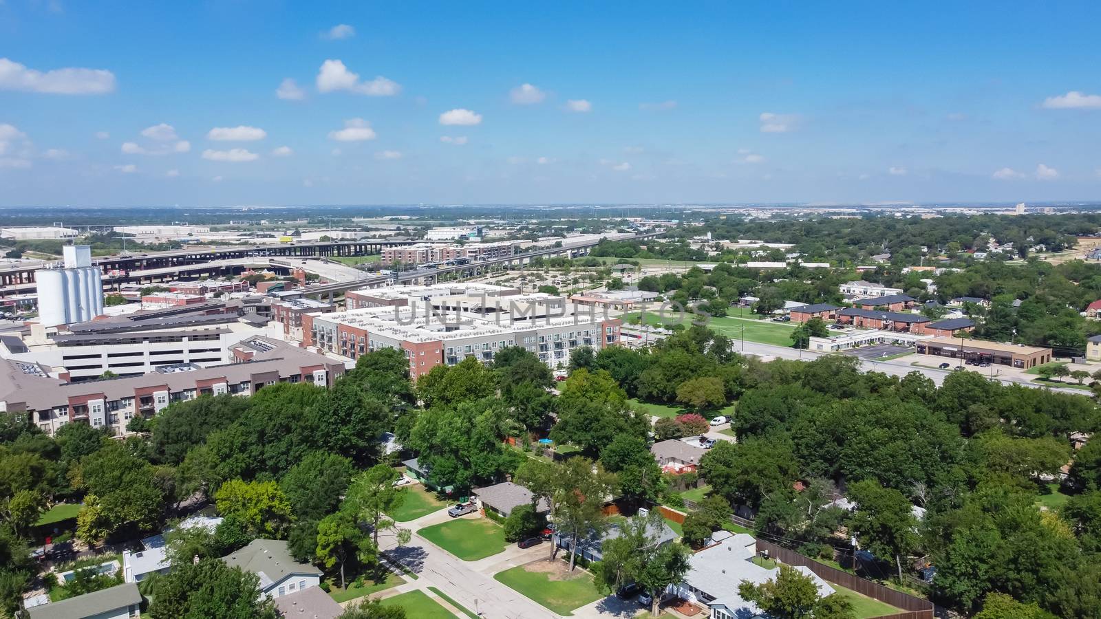 Aerial view green neighborhood with family houses next to rental buildings outside downtown Carrollton Square, Texas by trongnguyen