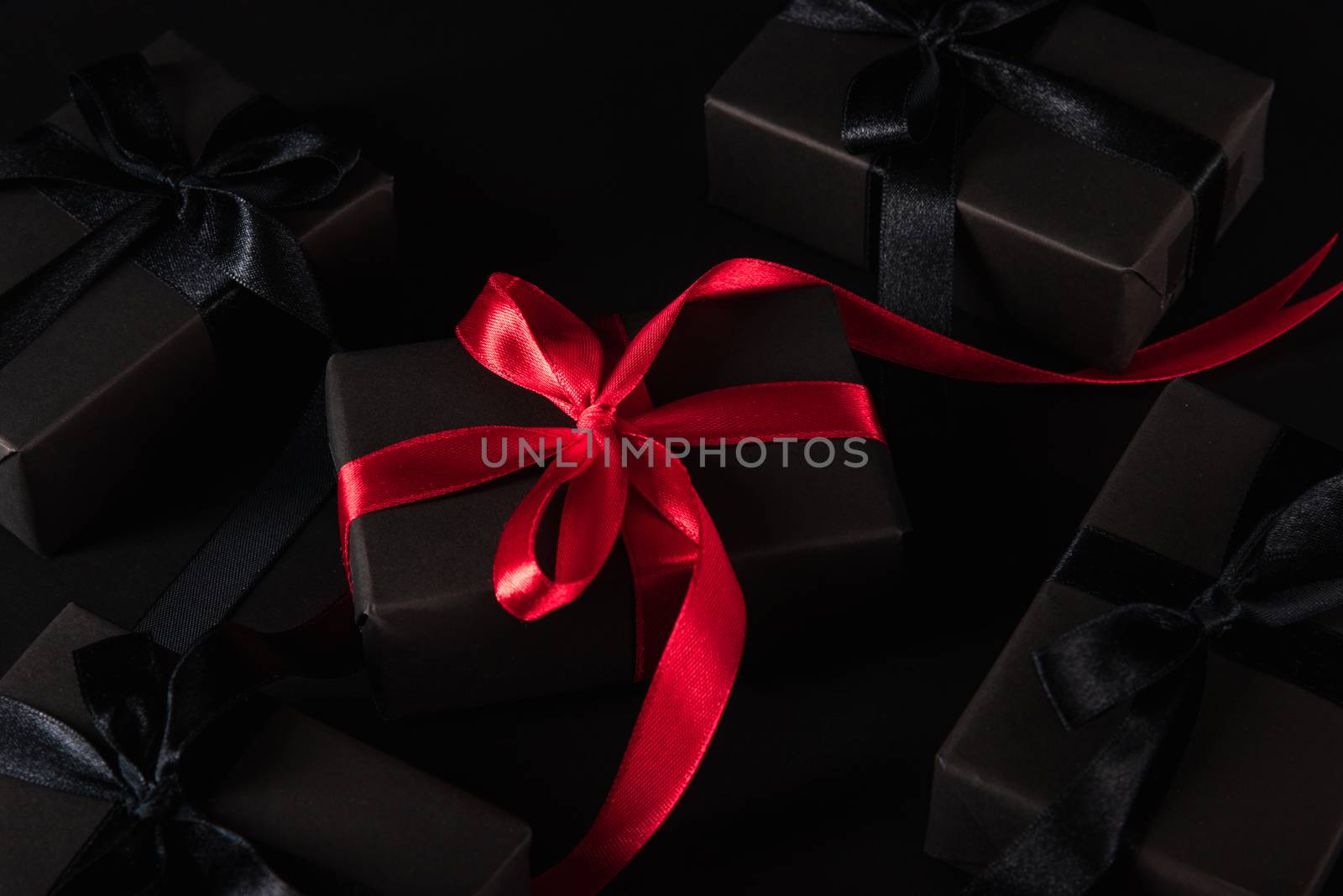 gift box wrapped black paper and black bow ribbon present around by Sorapop