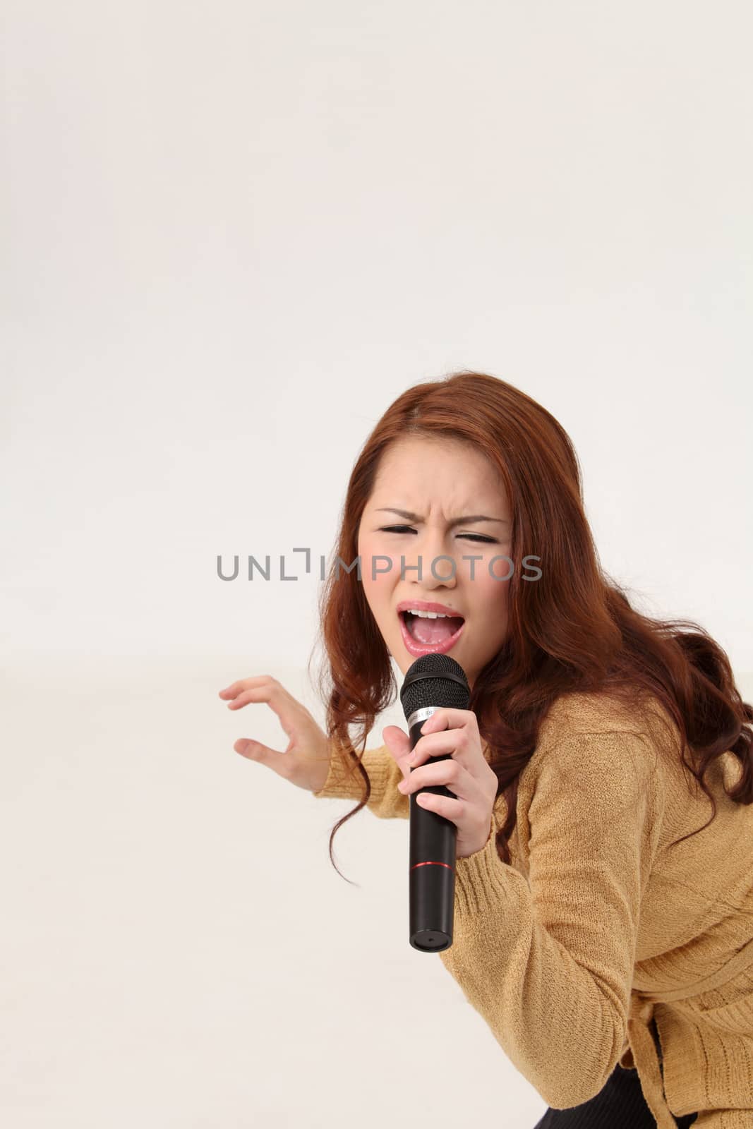 Woman singing, holding wireless microphone