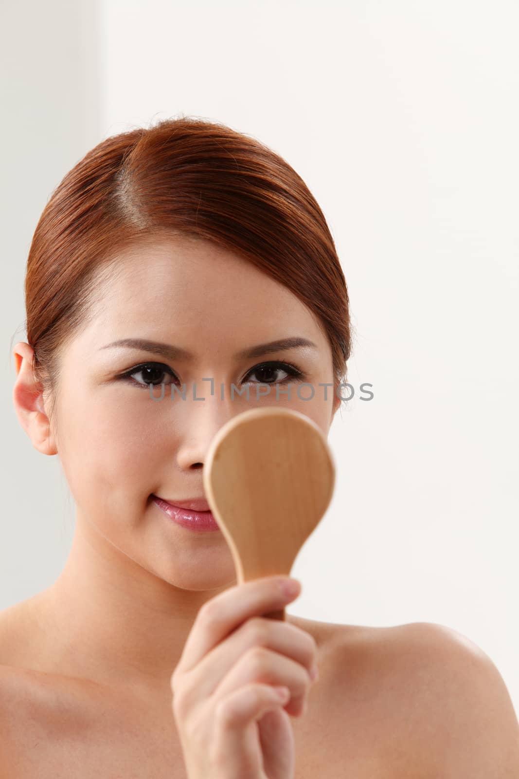 Young woman holding mirror on the white background