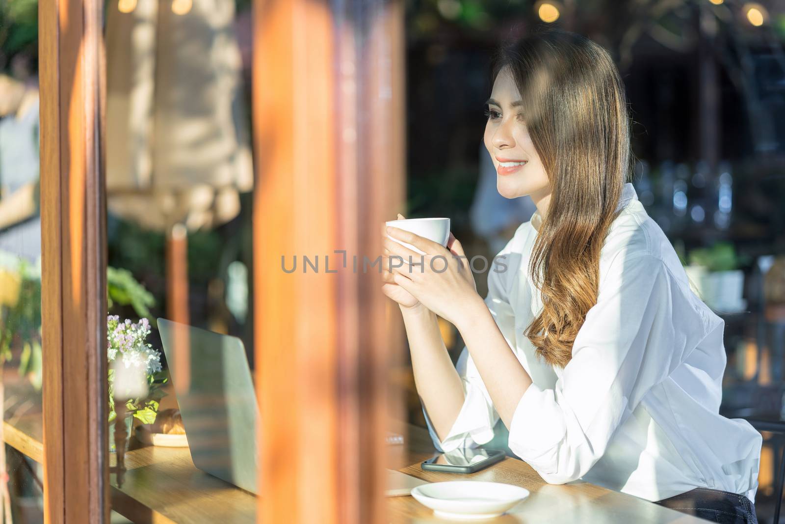 Portrait Young Asian woman holding and drinking a cup of coffee by Tzido