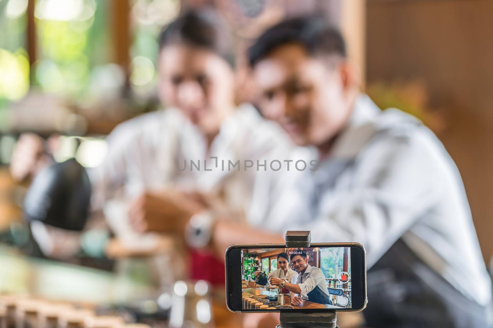 Smart mobile phone taking video to Asian two partner of small business owner vlogger showing and presenting the how to making coffee by drip method, entrepreneur blogger and startup business concept