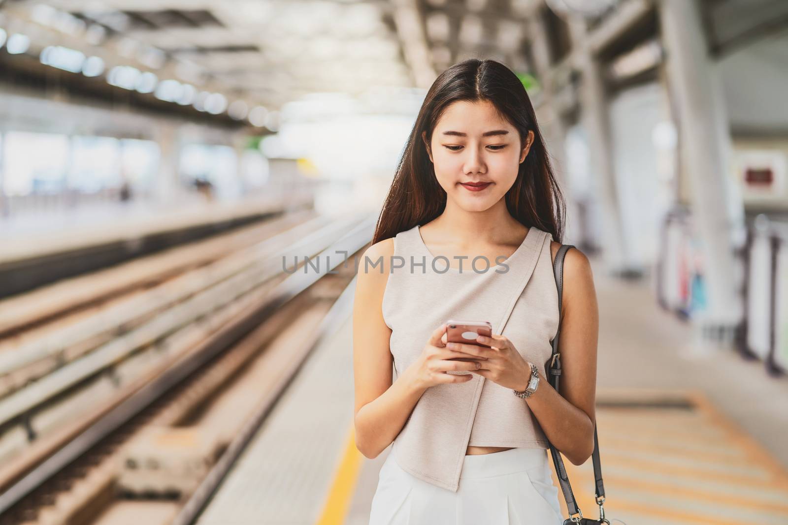 Young Asian woman passenger using social network via smart mobil by Tzido