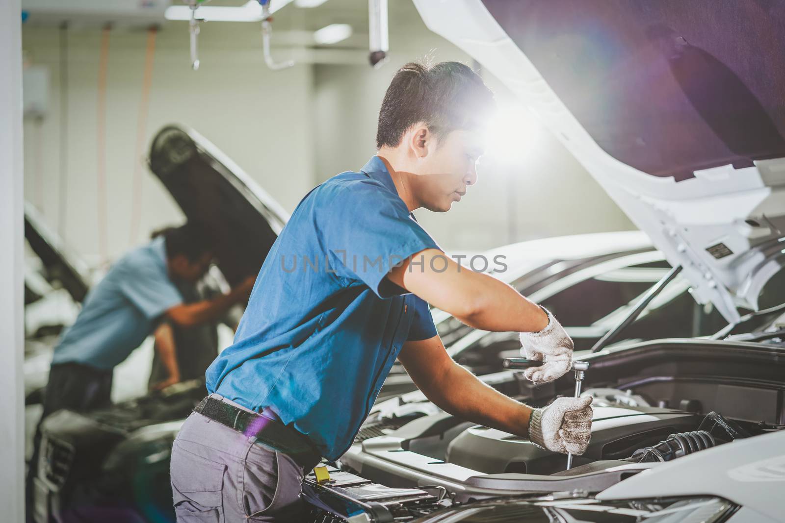 Asian mechanic Checking and repairing the car in maintenance ser by Tzido