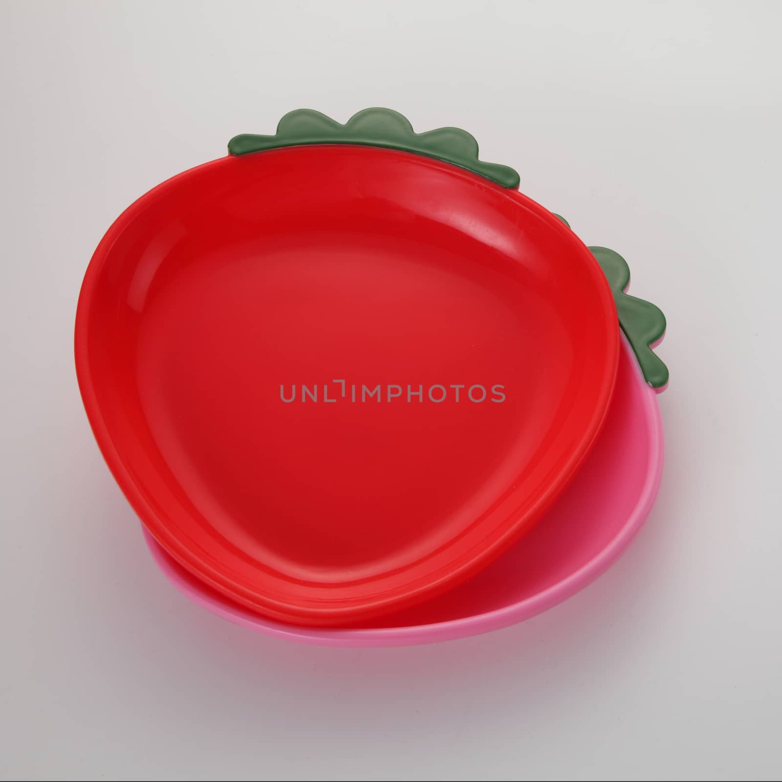 Red strawberry shaped plate on the white background