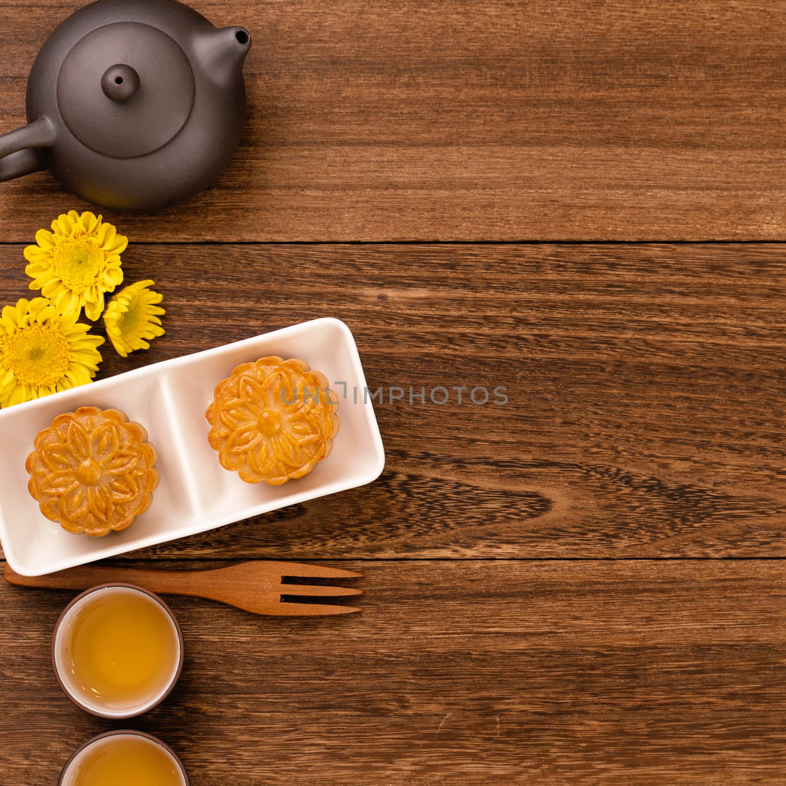 Moon cake for Mid-Autumn Festival, delicious beautiful fresh mooncake on a plate over dark wooden background table, top view, flat lay layout design concept.