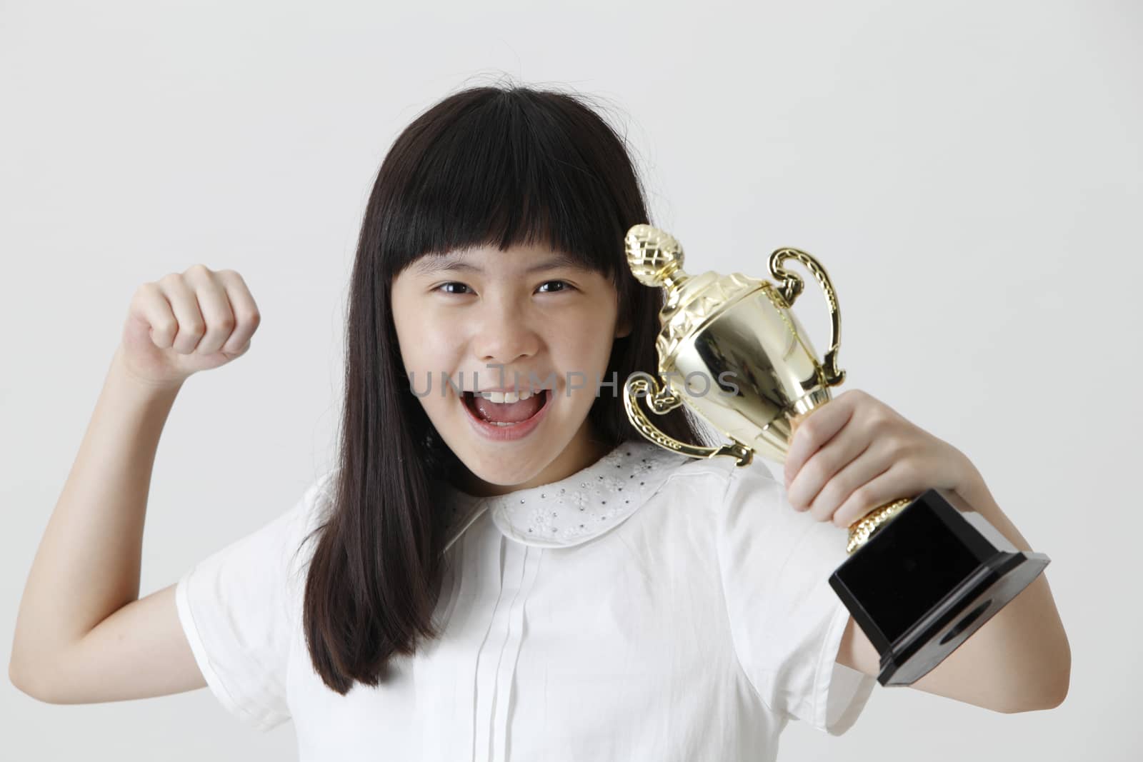 chinese girl holding trophy with raising her arm