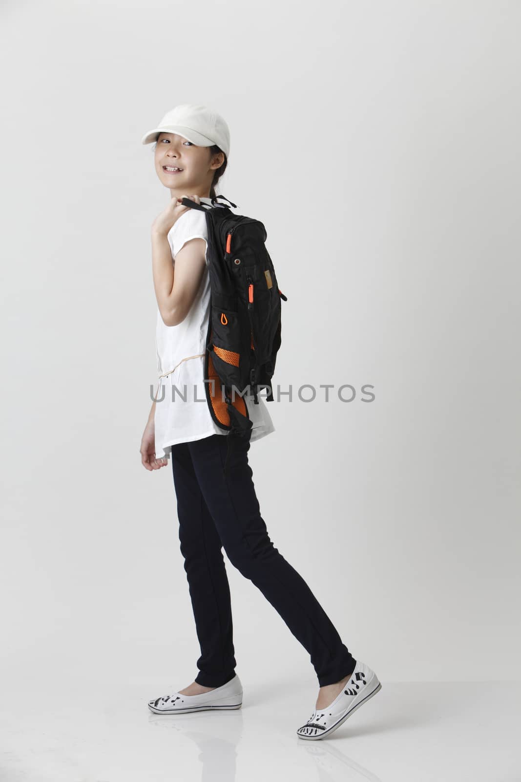 girl with backpack and cap in the walking position