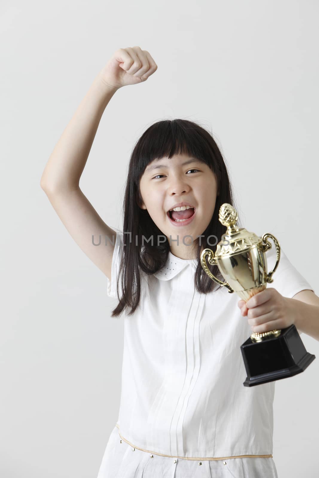 chinese girl holding trophy with raising her arm