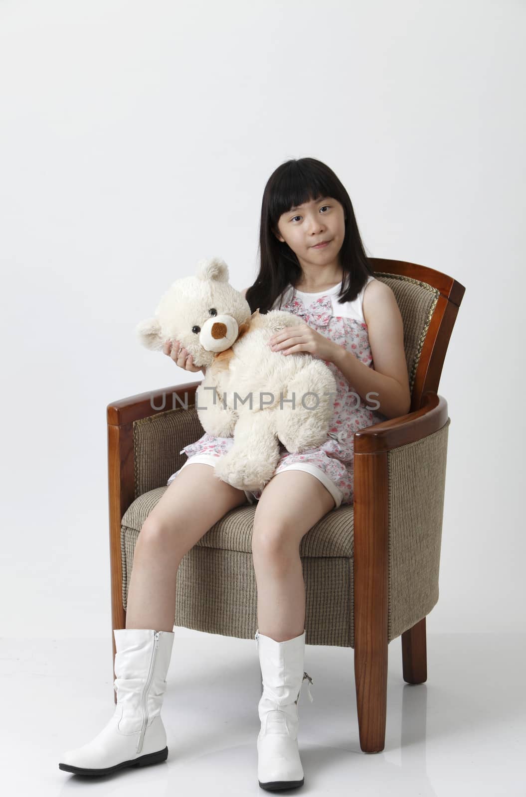 chinese girl holding teddy bear looking at camera
