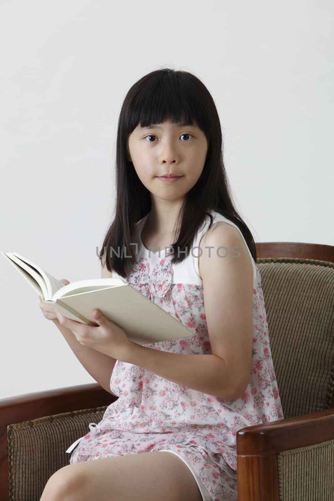 chinese girl holding book looking at camera