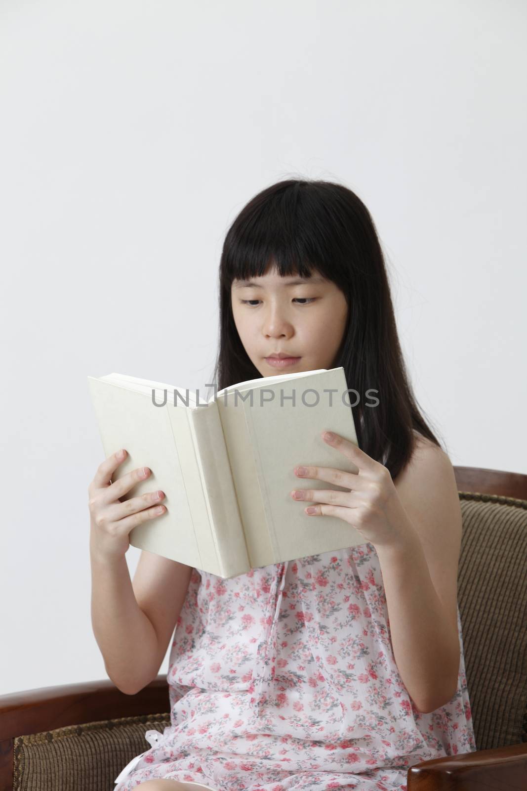 chinese girl sitting on the sofa reading books