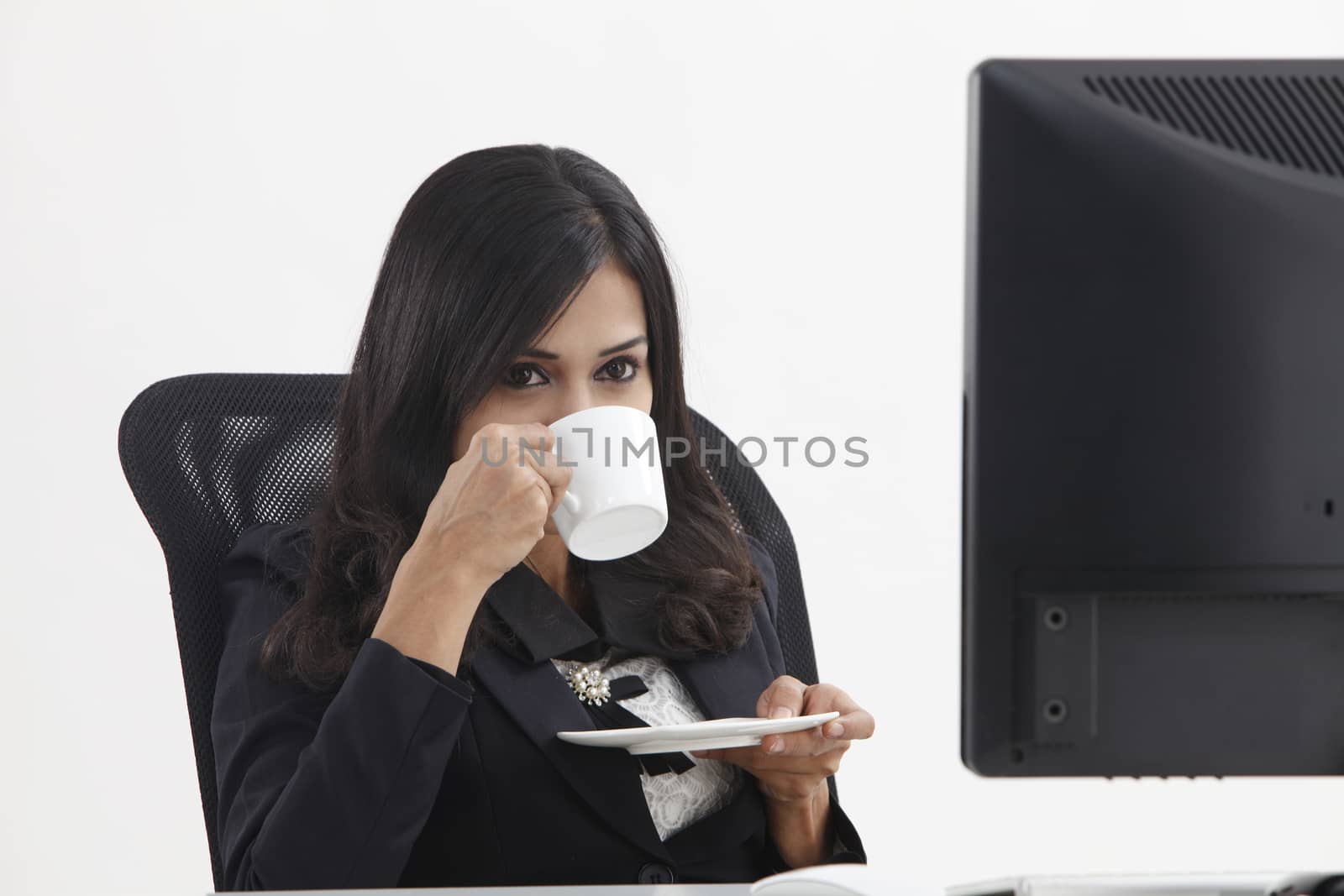 business woman sitting in front monitor having tea break