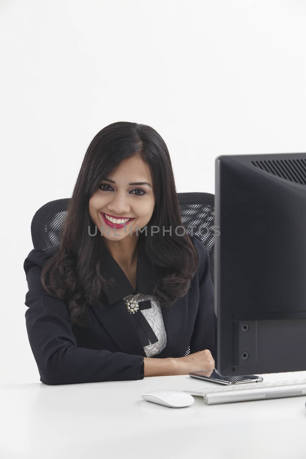 business woman sitting in front monitor looking at camera