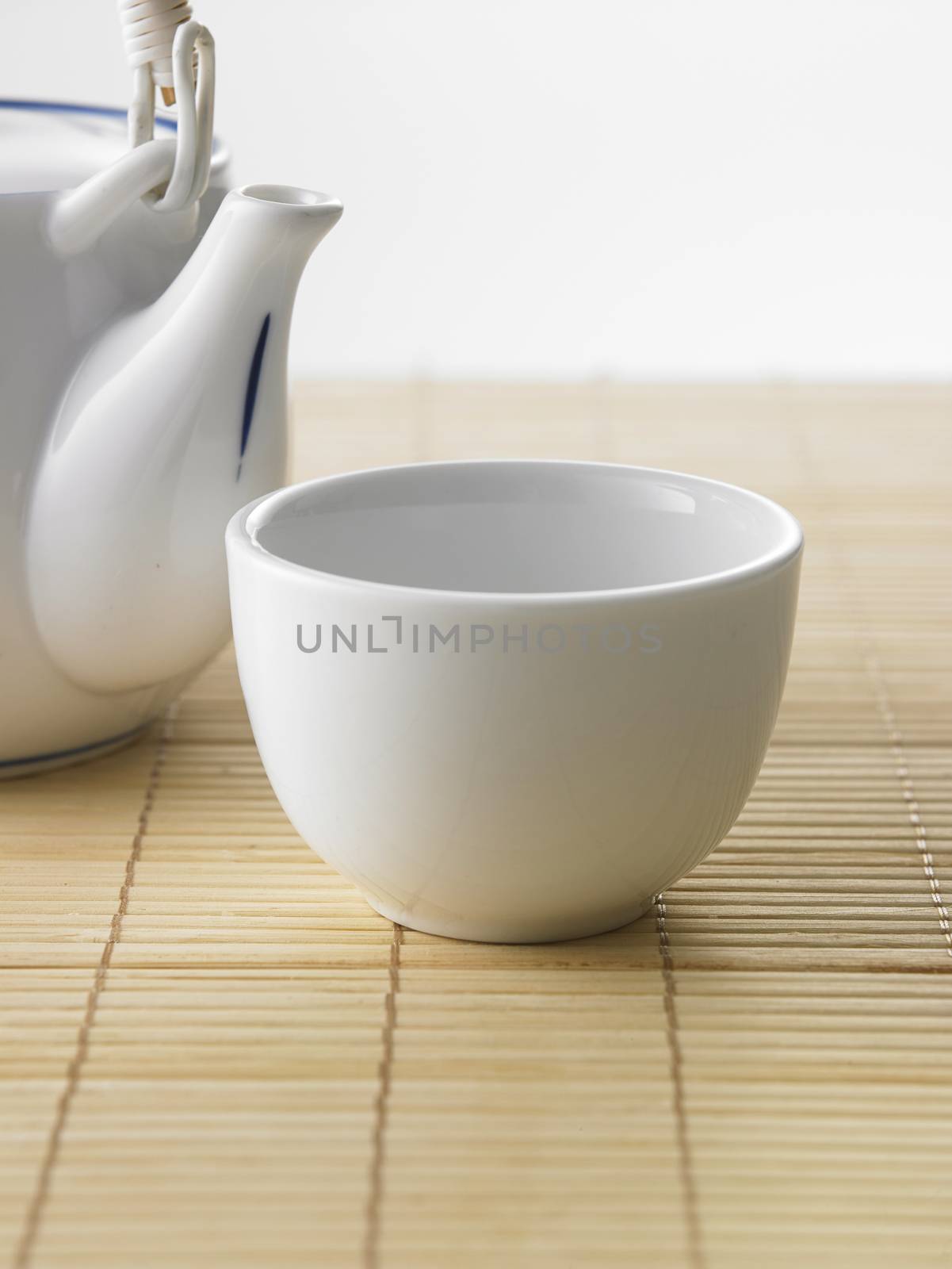 Japanese white tea pot on the bamboo mat