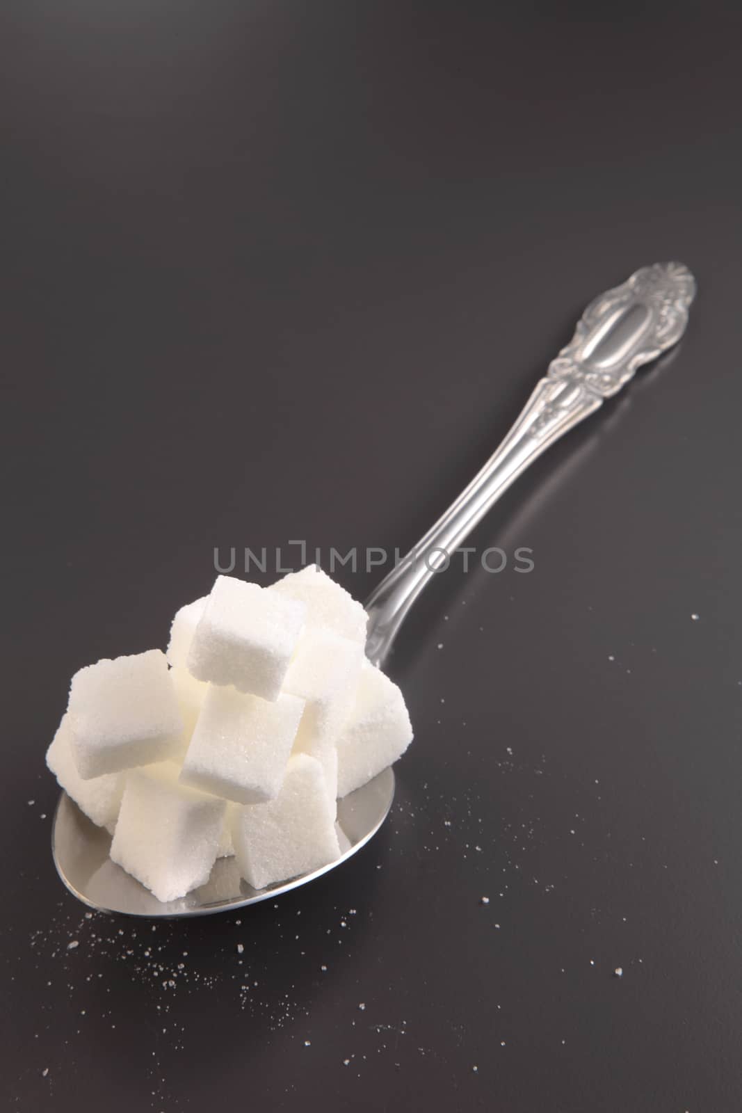 big or super size spoon with pile of cube white sugar