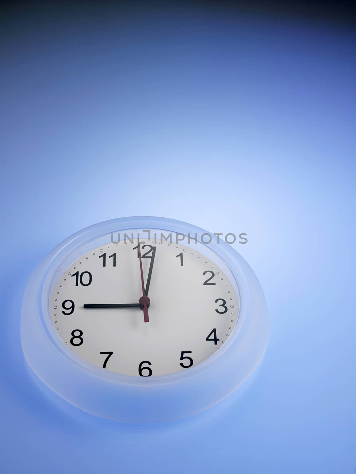 Clock showing 9 o'clock on a blue wall