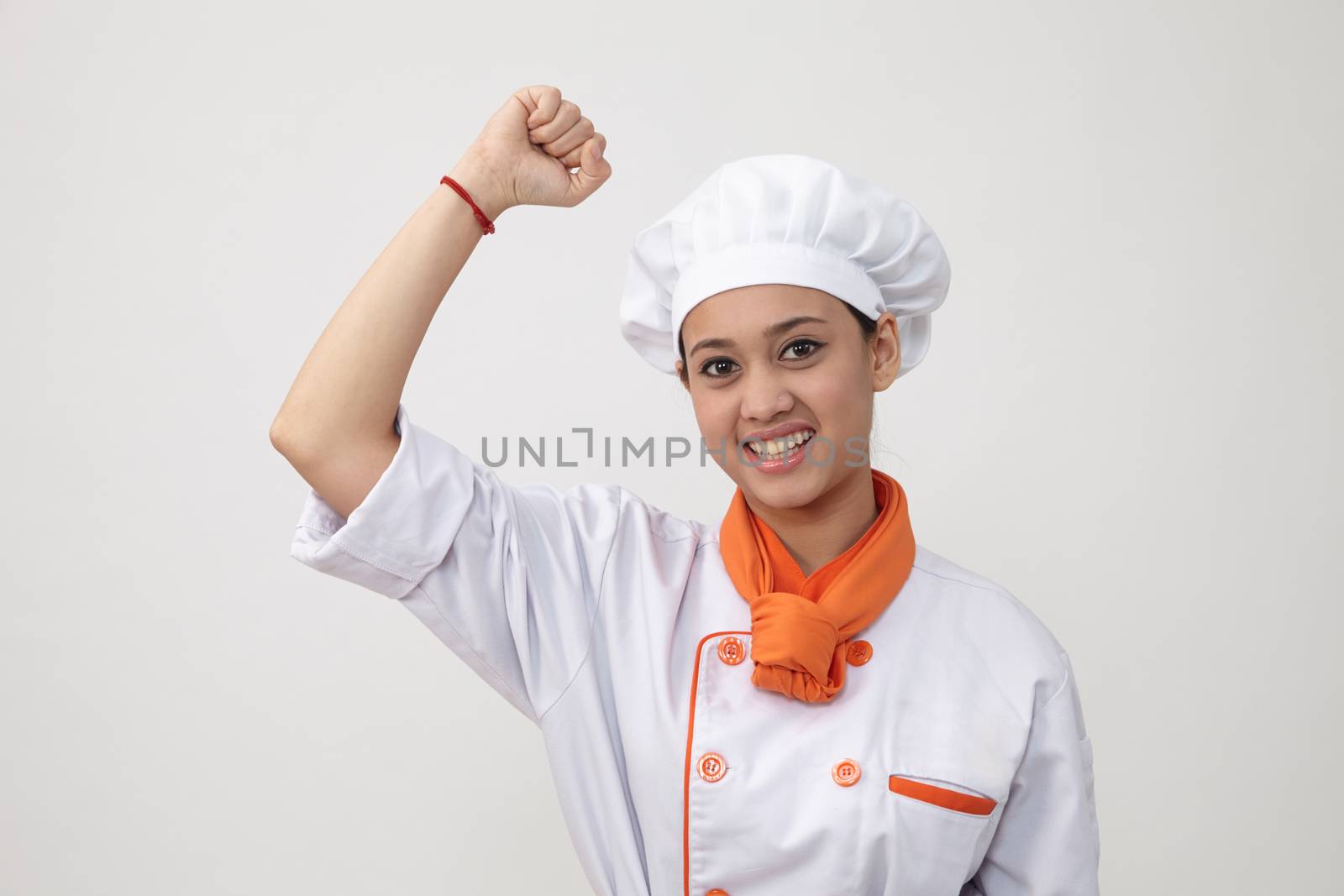 Portrait of a Indian woman with chef uniform with arm's up