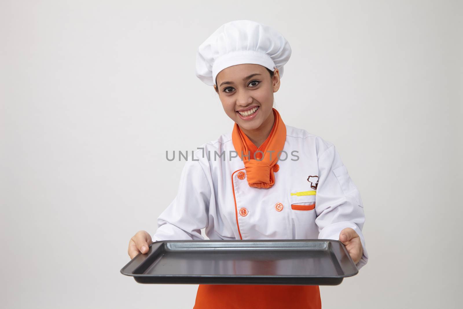 Portrait of a Indian woman with chef uniform holding an empty tray