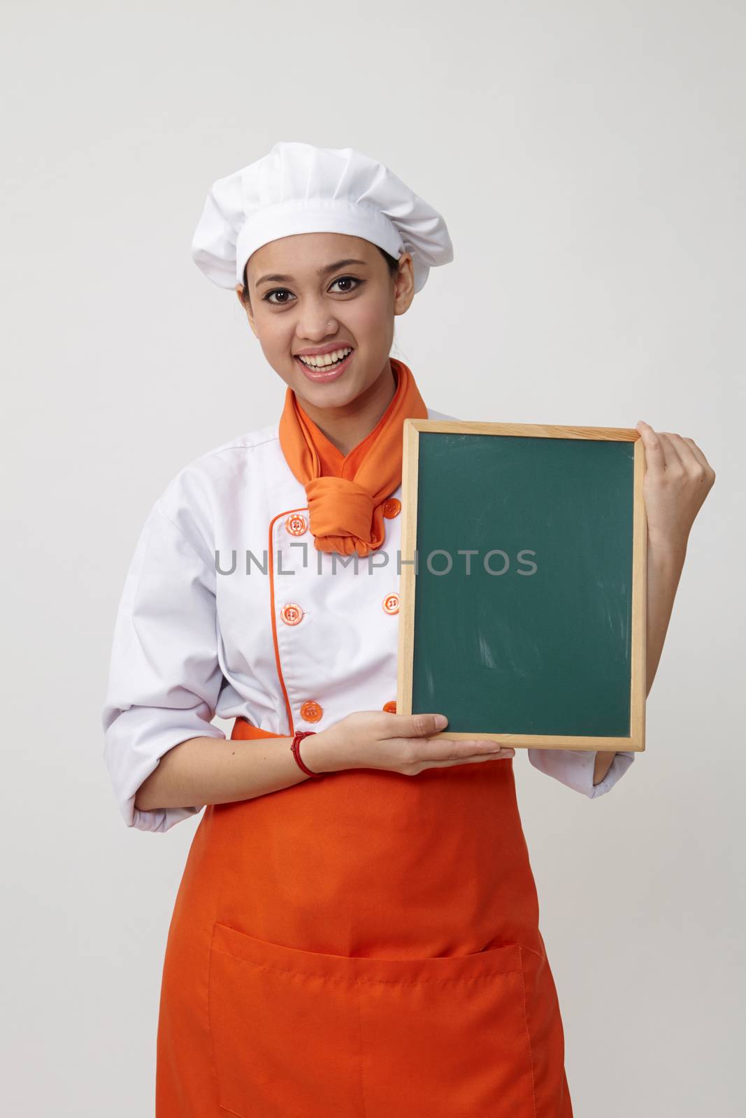Portrait of a Indian woman with chef uniform holding chalk board
