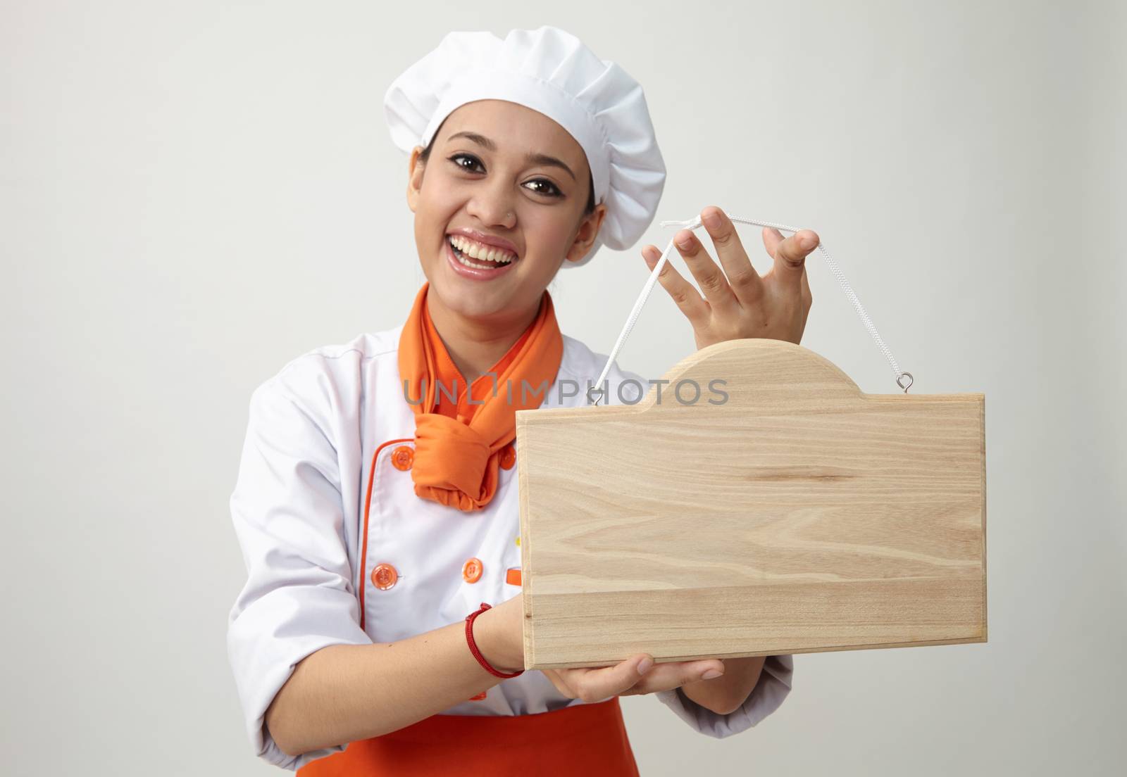  Indian woman with chef uniform holding a woden plank