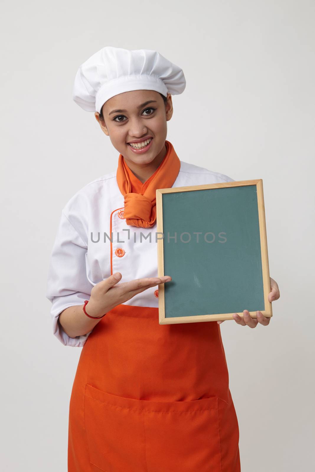 Portrait of a Indian woman with chef uniform holding chalk board