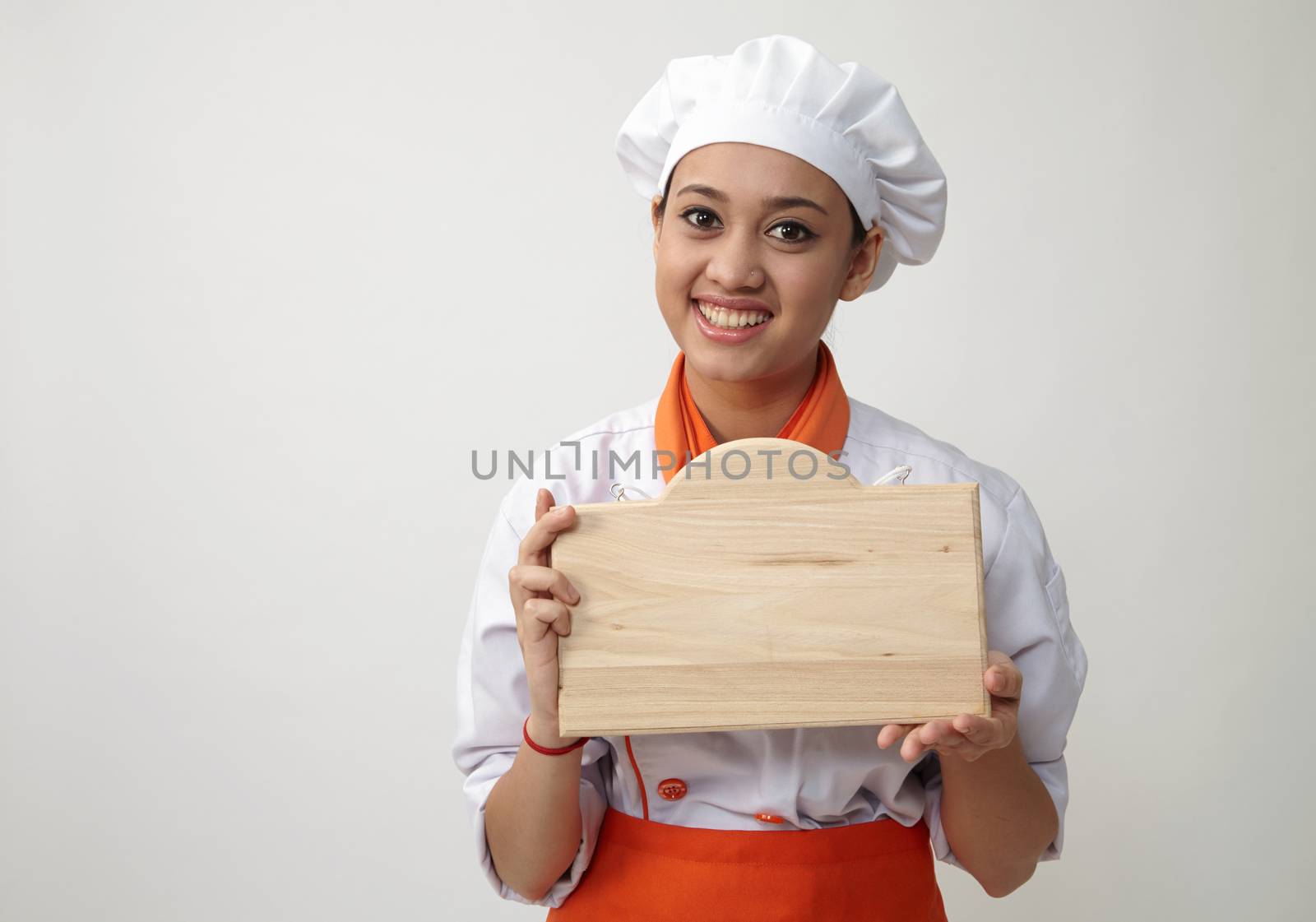  Indian woman with chef uniform holding a woden plank