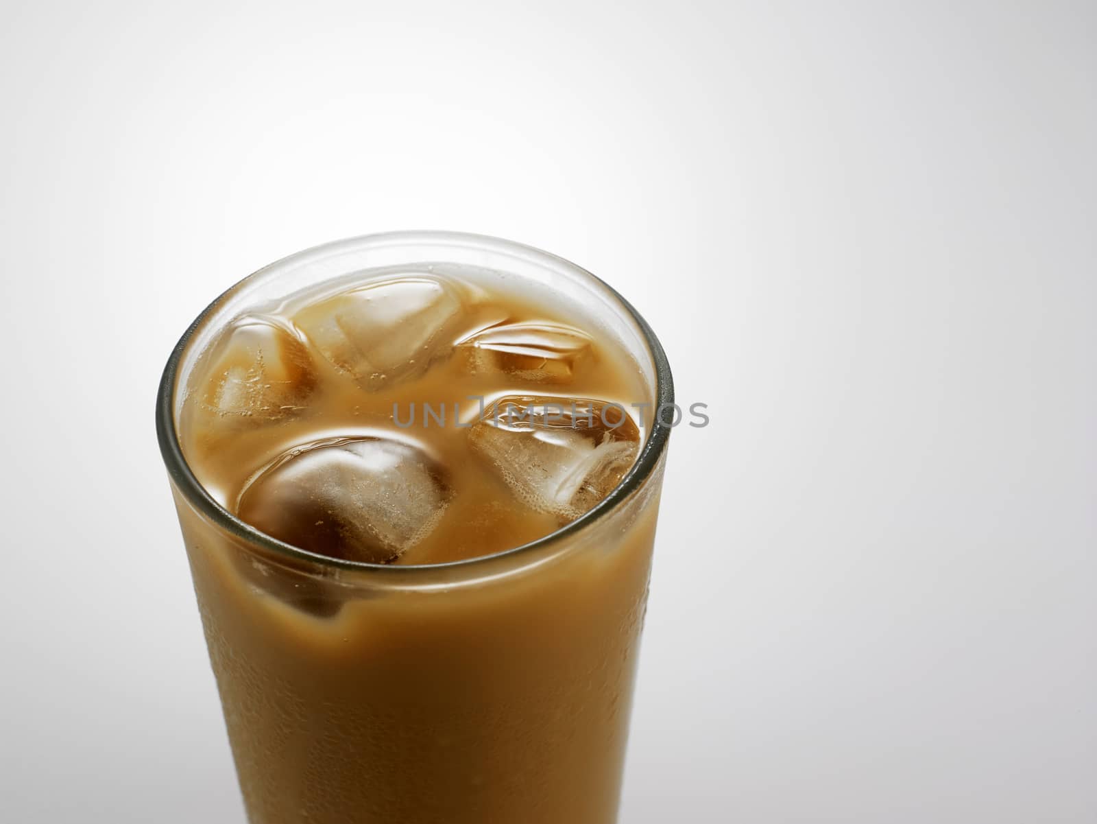 Ice coffee in a glass over gray background