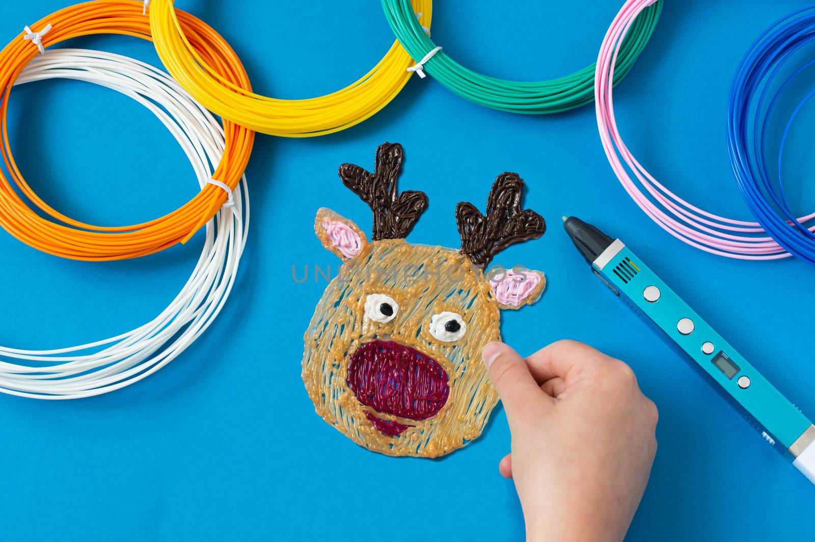 Child makes toys for Christmas tree with 3D pen. Original art project for children. New technology. DIY concept. Step by step photo instruction. Step 7. Make Santa's reindeer