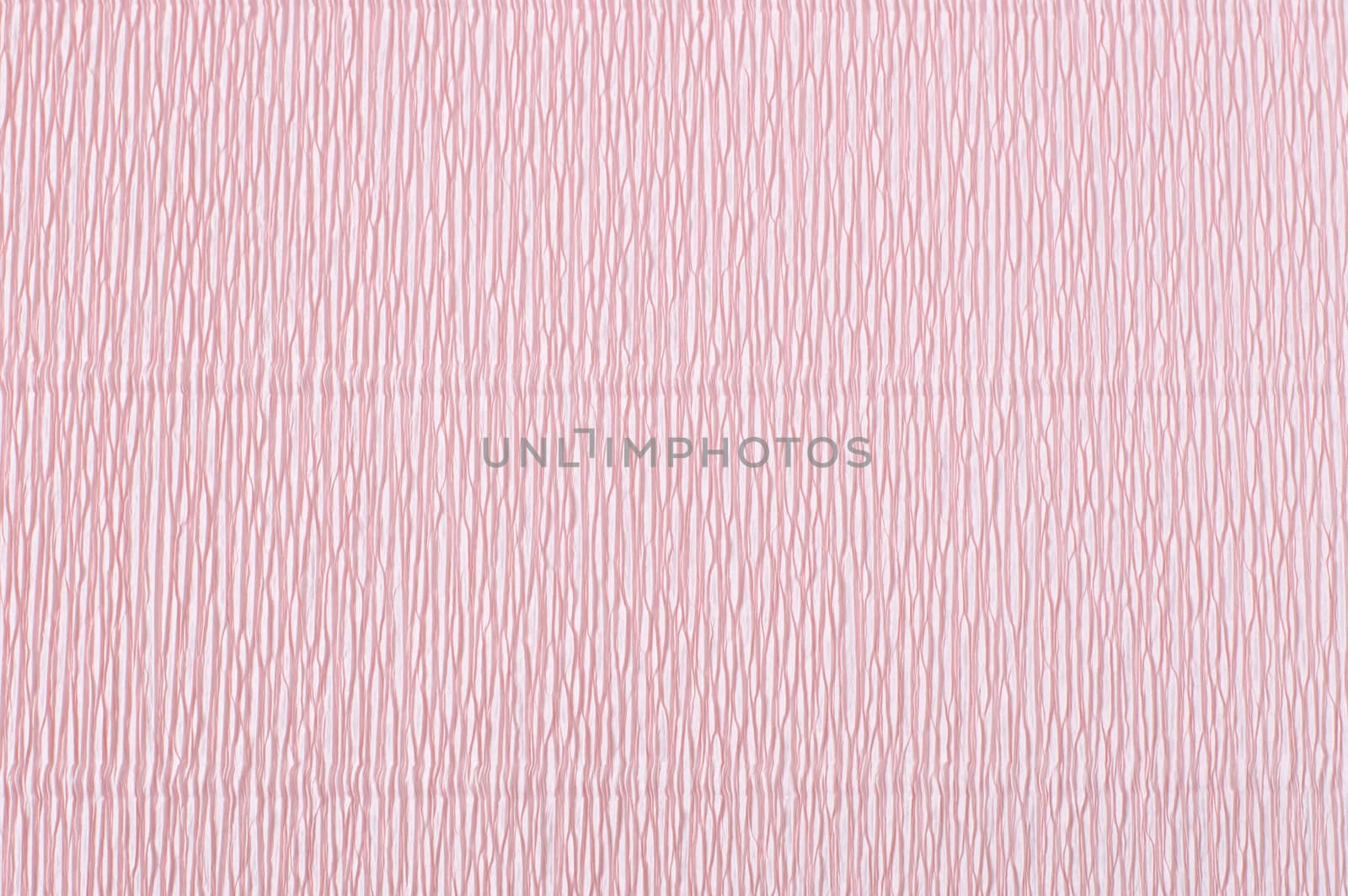 Pink corrugated paper. Crepe paper texture. Light pink abstract paper background. Paper wrinkles, wavy surface