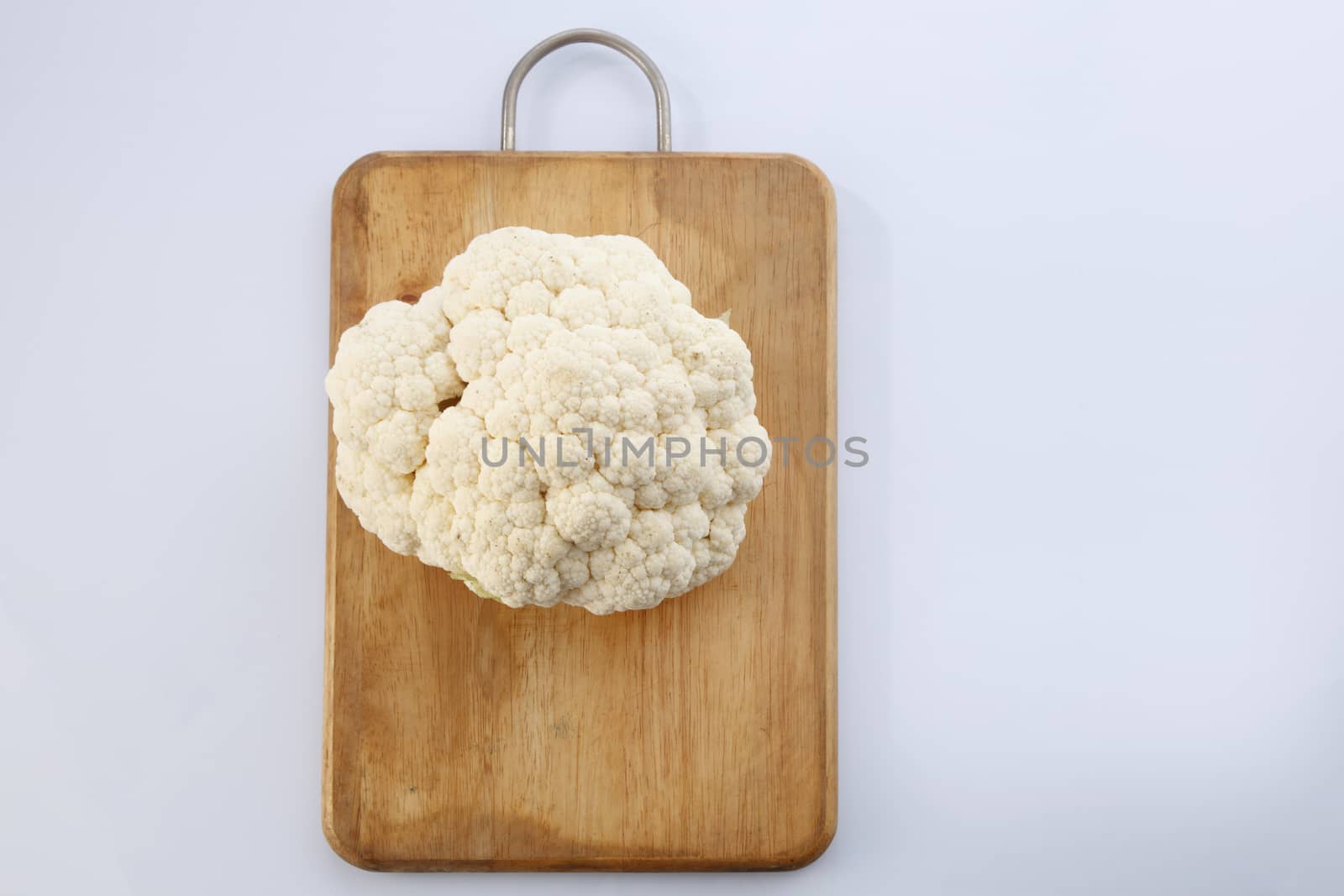 Cauliflower isolated on top of cutting board