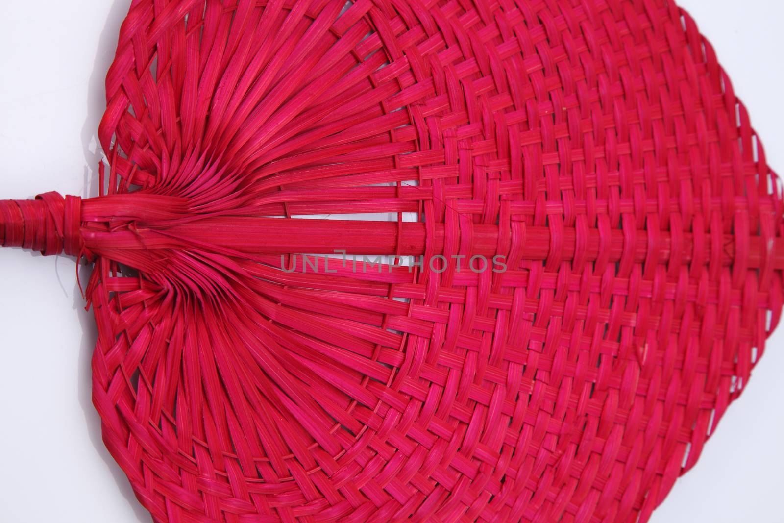 Red color native fan made from palm leaves on white background