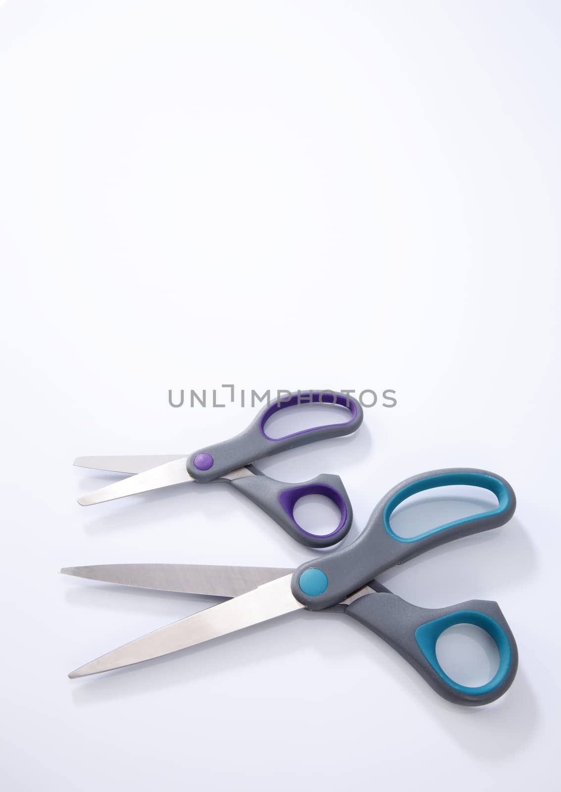 two pair of scissors which one big and small on the white background
