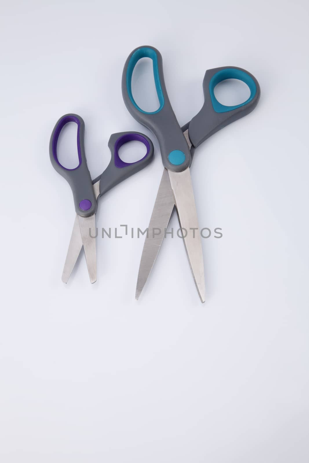 two pair of scissors which one big and small on the white background