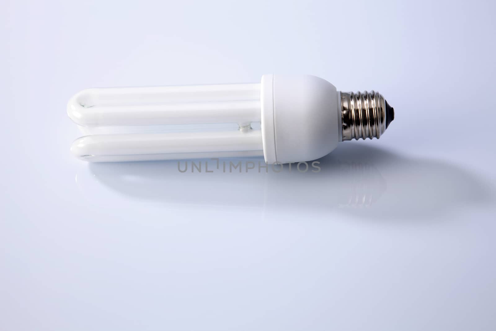 Energy saving fluorescent light bulb on white background