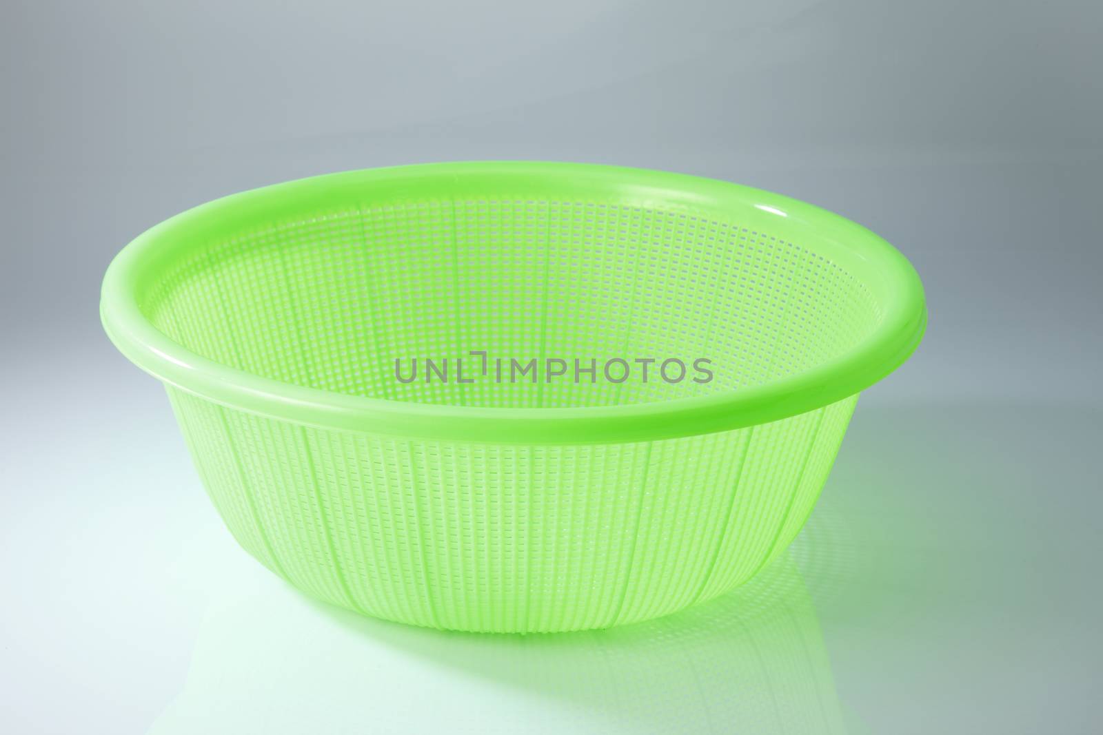 green plastic basket on a white background