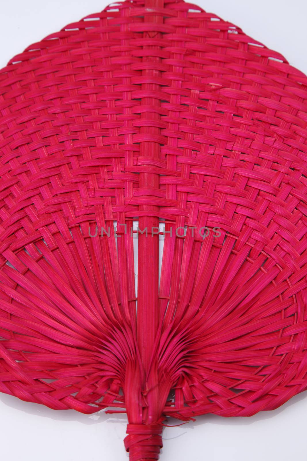 Red color native fan made from palm leaves on white background