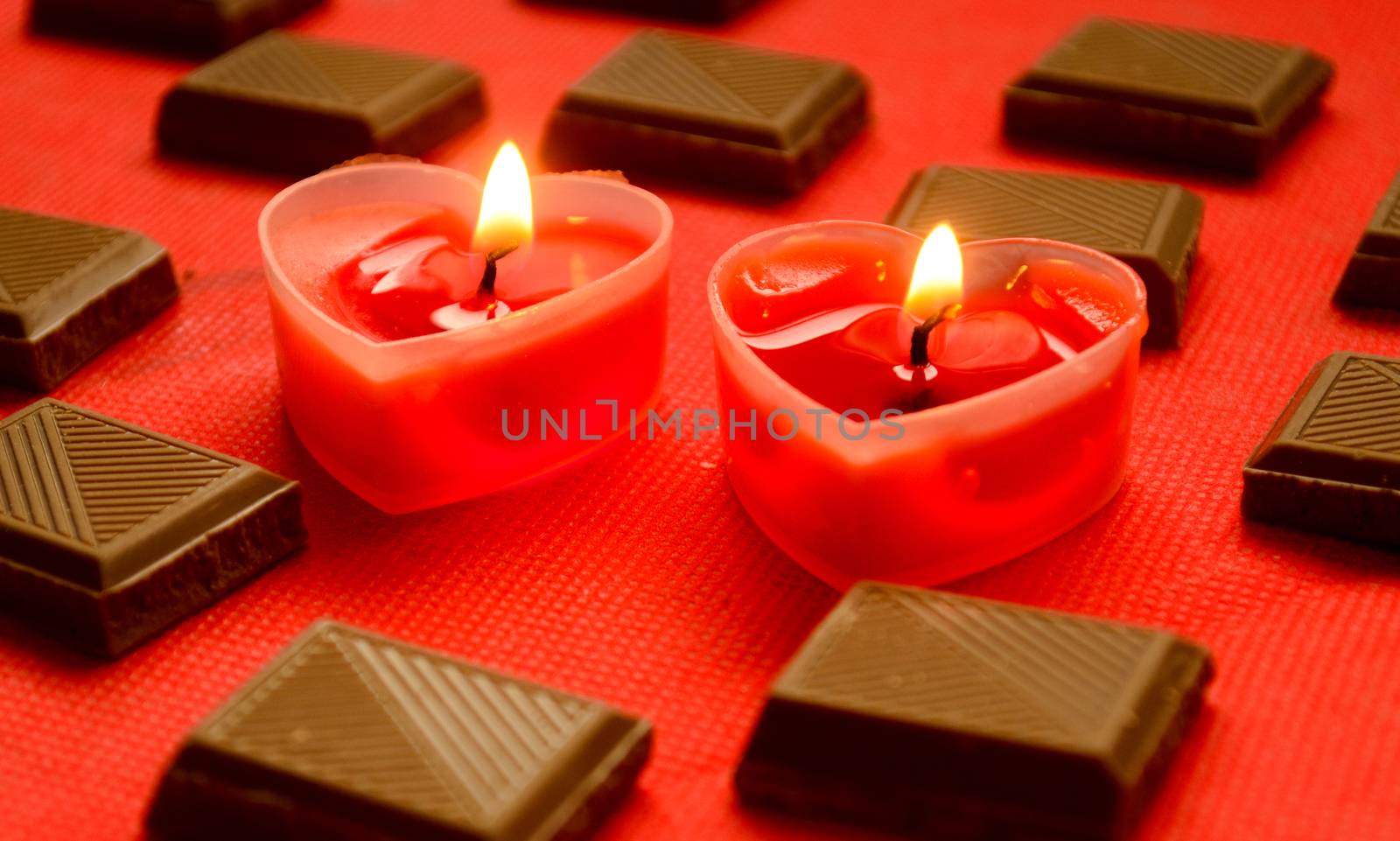 Two love burning hearts with chocolate bars on red background.Merry Valentine Day for lovers.