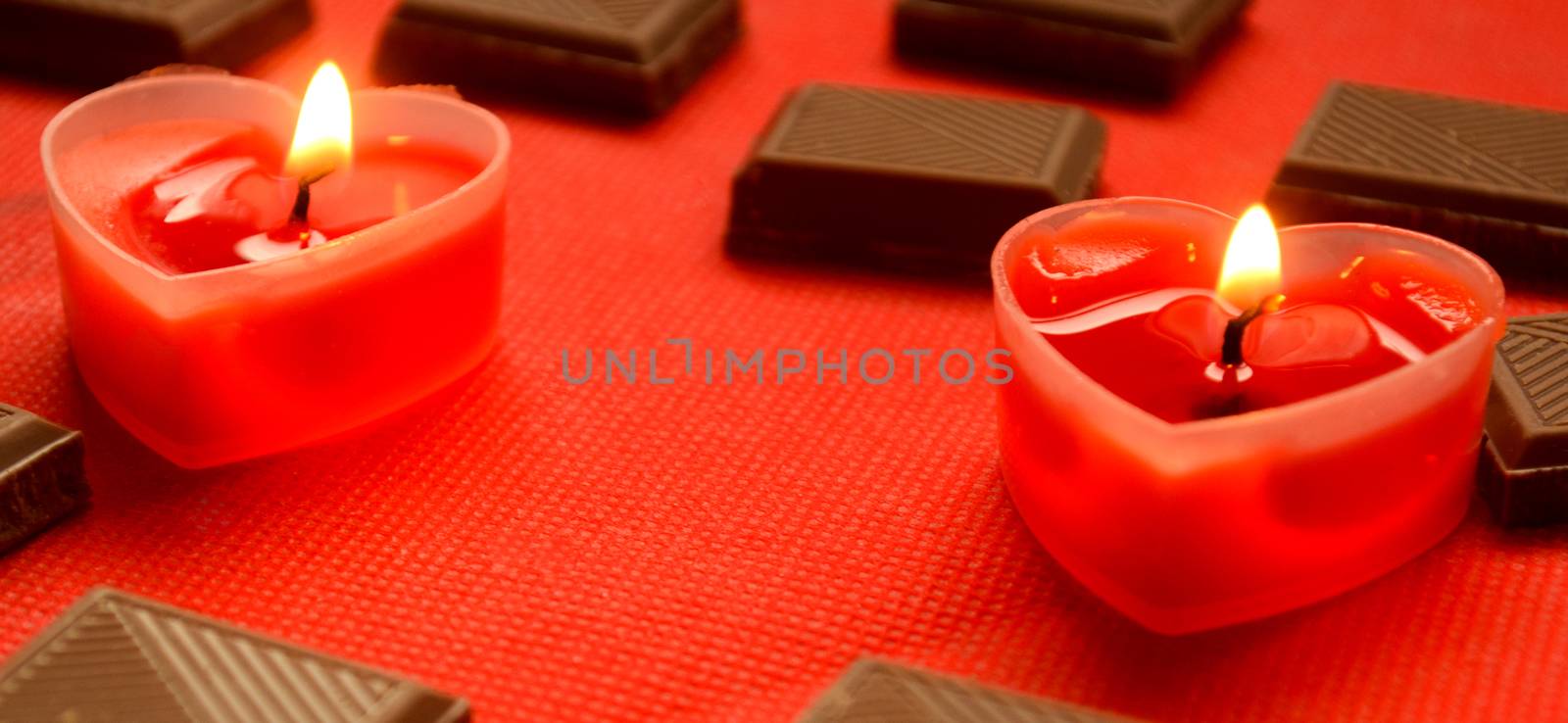 Two love burning hearts with chocolate bars on red background, copyspace.Merry Valentine Day for lovers.