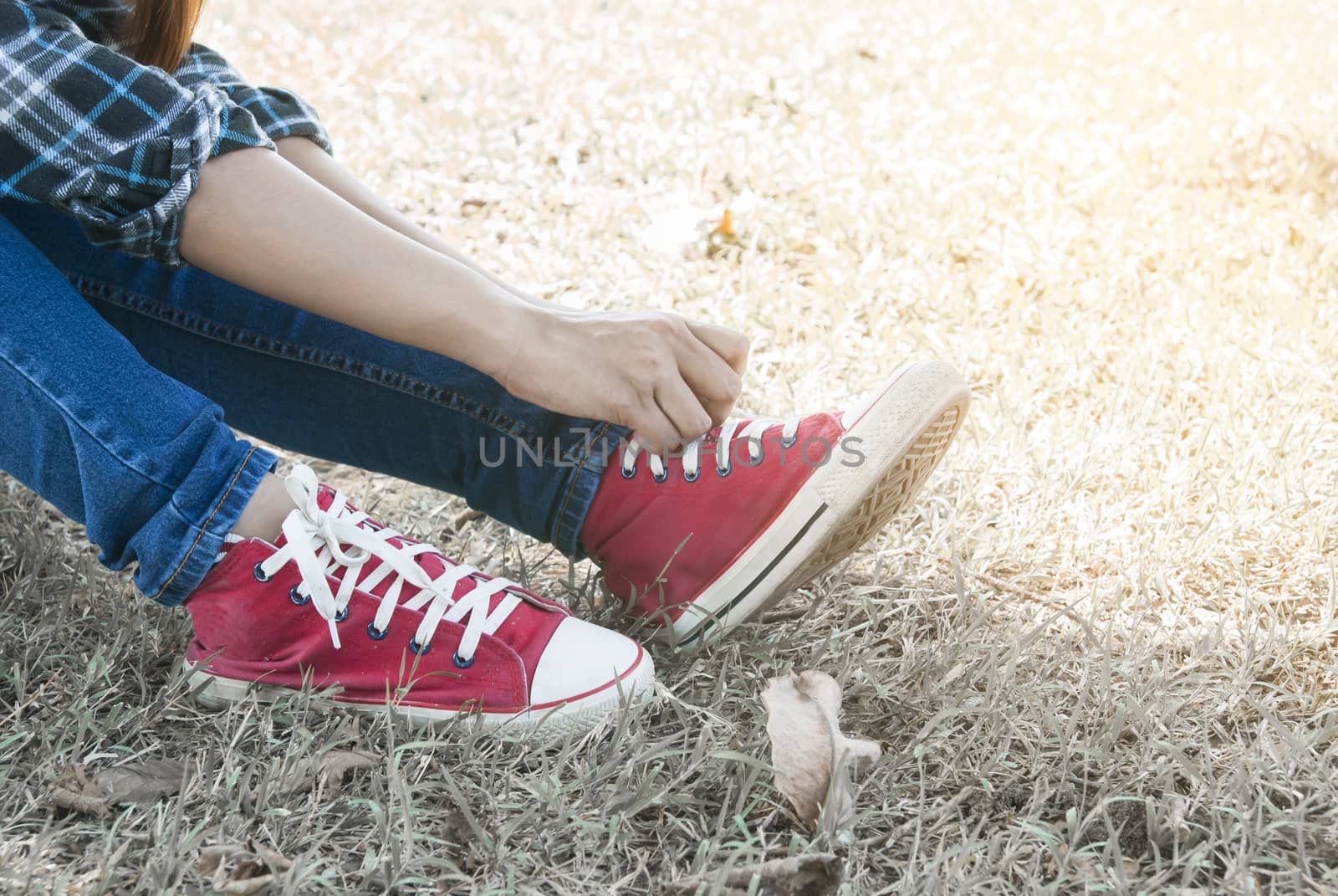close up of woman tying shoe laces in summer