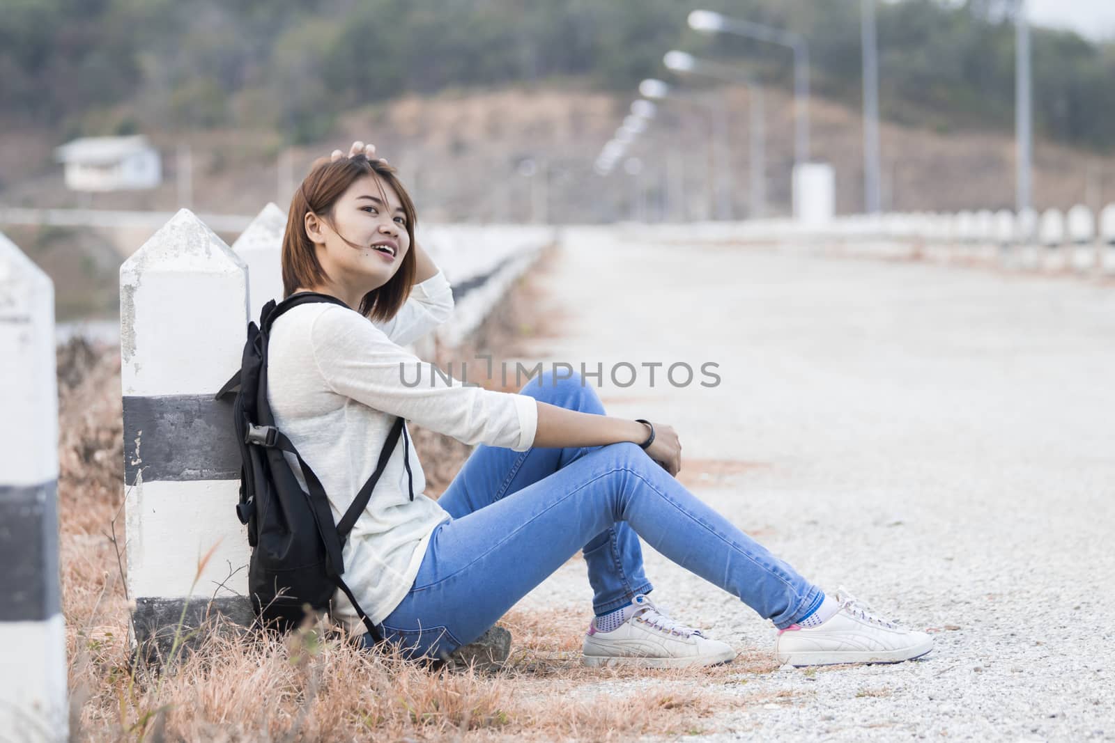 Young happy woman having fun outdoors sitting