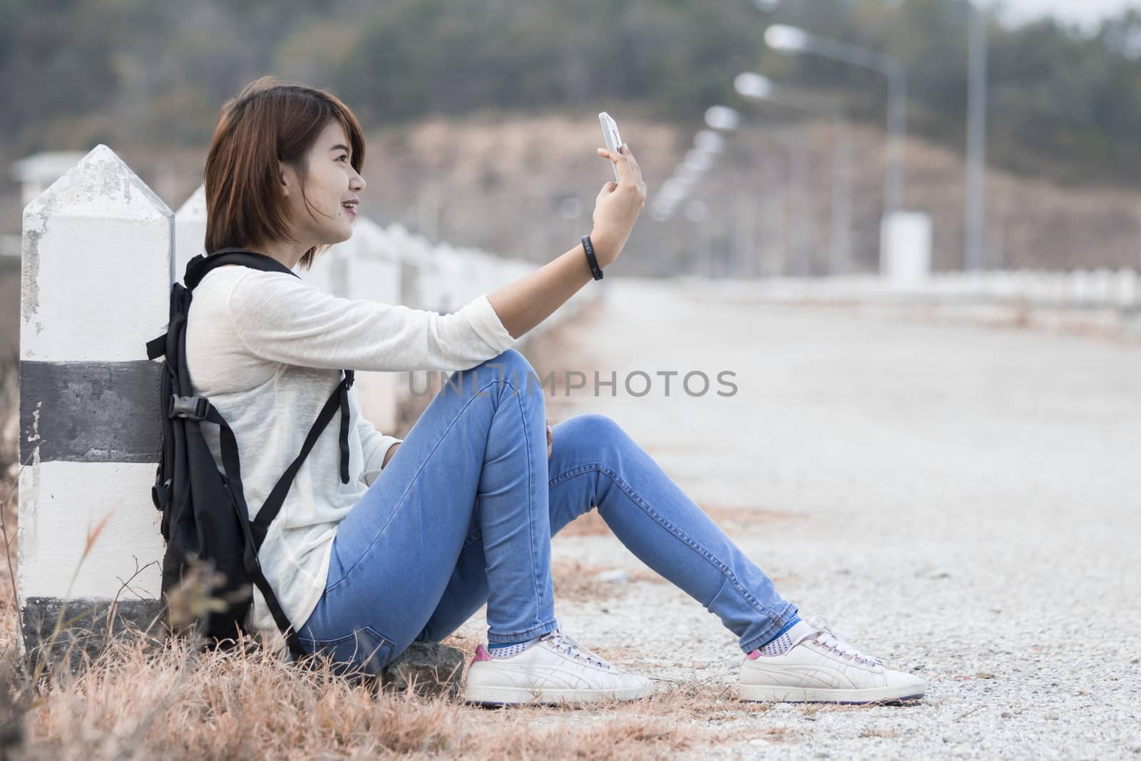 Young happy woman having fun outdoors sitting taking photo by Gobba17
